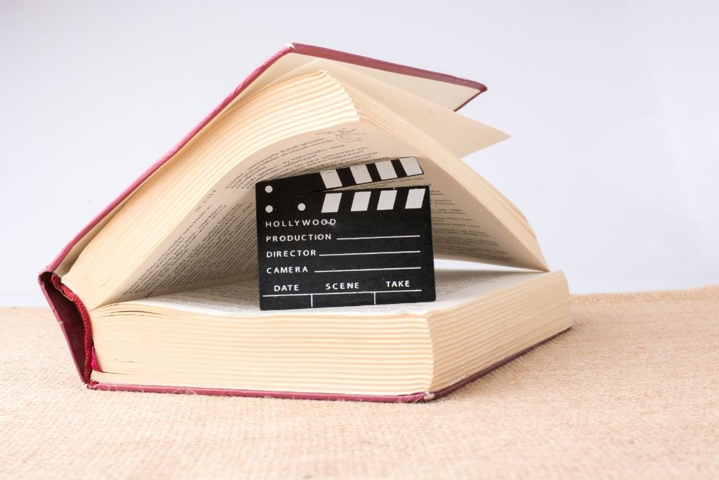 Open book with a movie clapperboard inside, fusing reading with filmmaking, reflecting Once Upon a Book Club's creative storytelling.