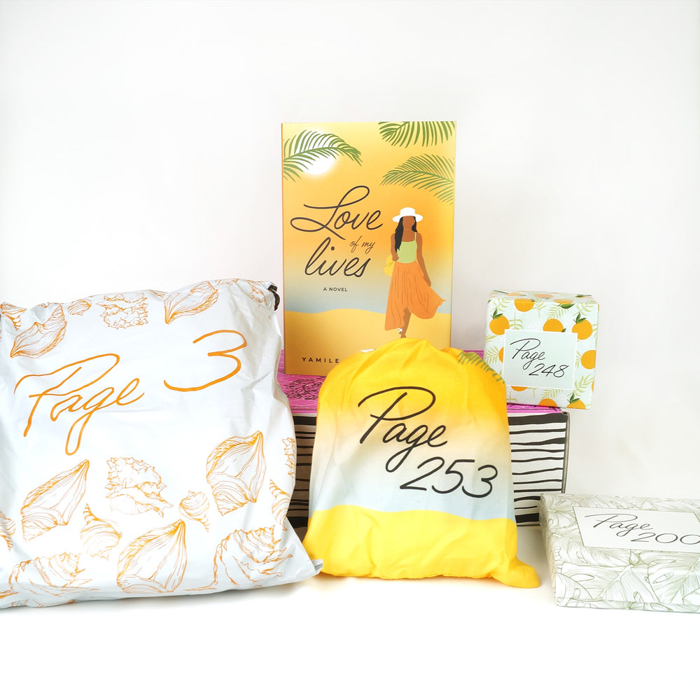 a hardcover copy of Love of My Lives and a square box with oranges on it sit on a pink box. In front of the box are a white bag, a yellow drawstring bag, and a square box with palm fronds on it. The boxes and bags all have page numbers.