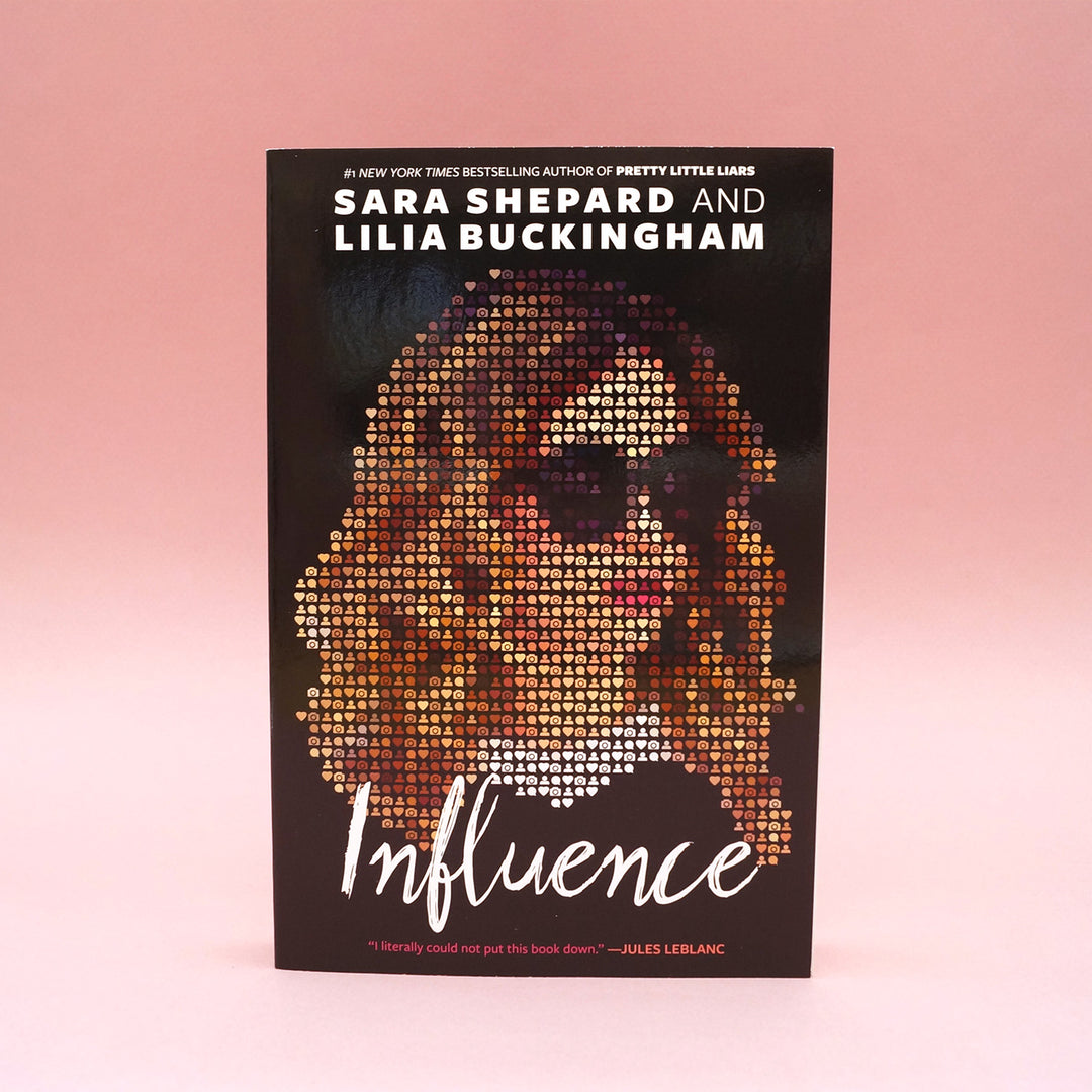 A paperback copy of Influence by Sara Shepard and Lilia Buckingham on a pink background.