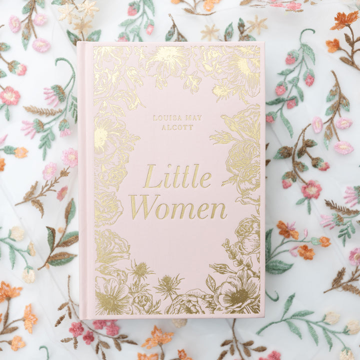 Book titled 'Little Women' with pink fabric and gold foiling on a floral background