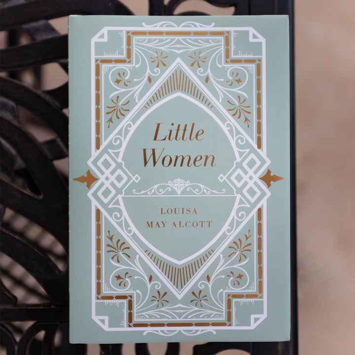 Book titled 'Little Women' by Louisa May Alcott with decorative mint green, white, and gold cover design.