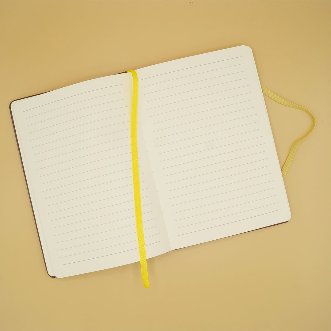 a journal with lined paper lays open with a yellow bookmark over the center