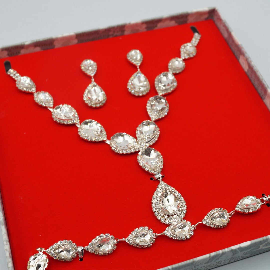 In a red velvet box lays a pair of CZ drop earrings, CZ teardrop pendant necklace, and CZ teardrop bracelet.