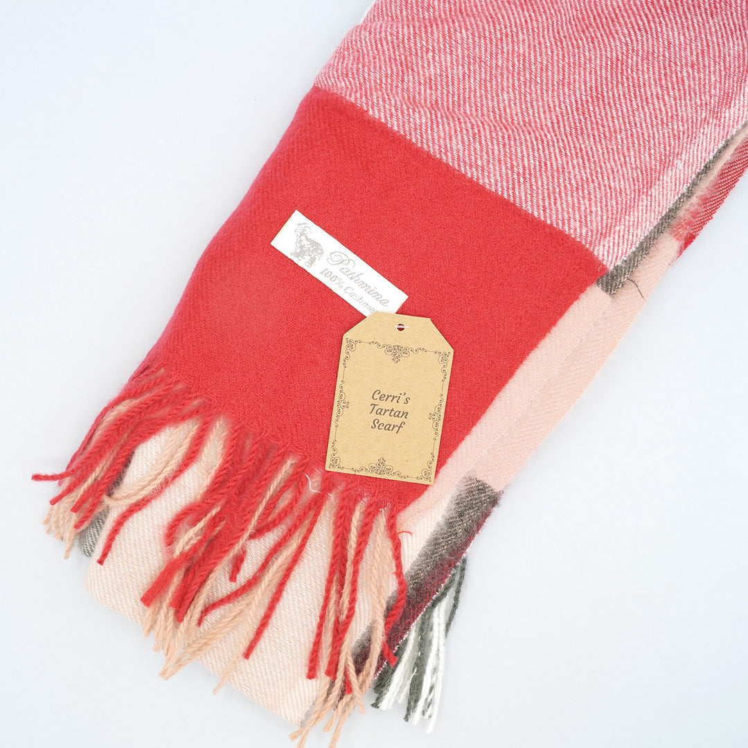 a red cashmere scarf with the label Cerri's Tartan Scarf on top of it