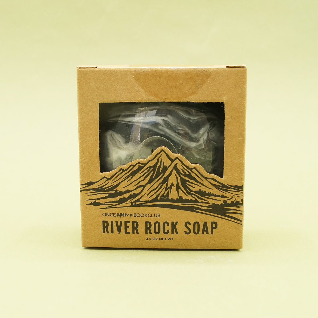 A cardboard box with cutout around mountains reads "River Rock Soap".