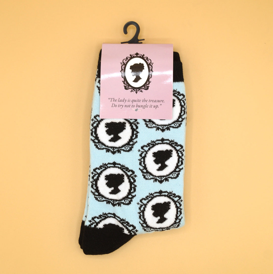 a pair of socks that are light blue and black with the pattern of a woman's silhouette sideways in the mirror