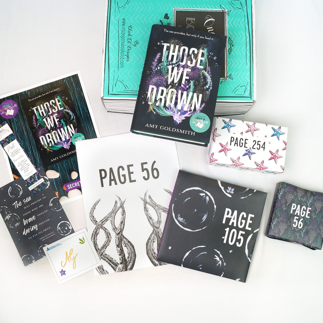 a hardcover edition of Those We Drown is on a green box. In front of the box (from left to right) is a bookclub kit, bookmark, quote card, signature card, white folder, black square folder, white rectangular box, and black square box. The boxes and folders all have page numbers.