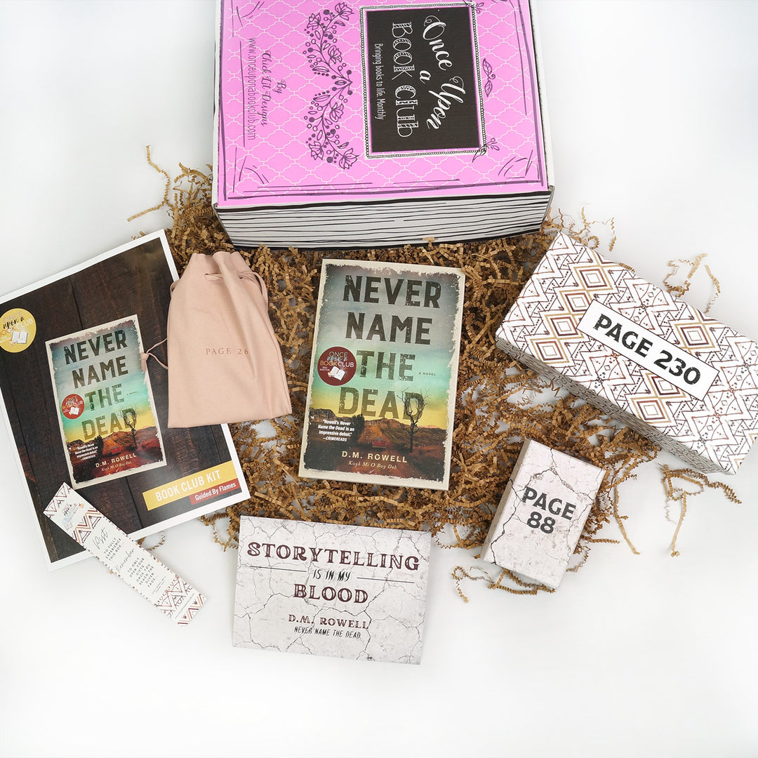 A pink Once Upon a Book Club box is at the top of the image. Below (from left to right) are a bookclub kit, bookmark, pale pink drawstring bag, quote card, paperback edition of Never Name the Dead, and two white boxes. The boxes and bag are all labeled with page numbers.