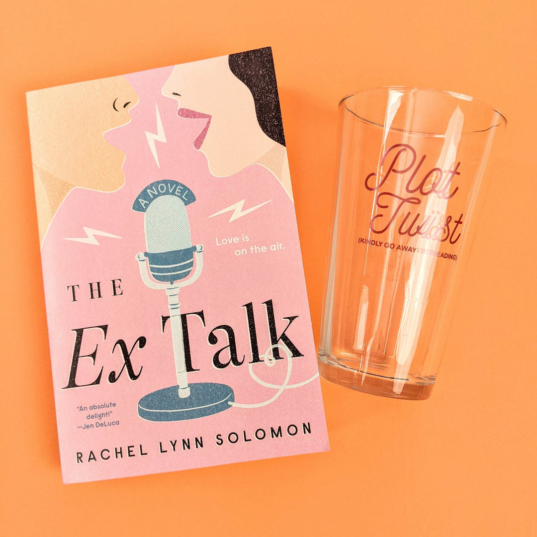 A paperback edition of The Ex Talk is next to a pint glass that says "Plot Twist" in pink writing on it