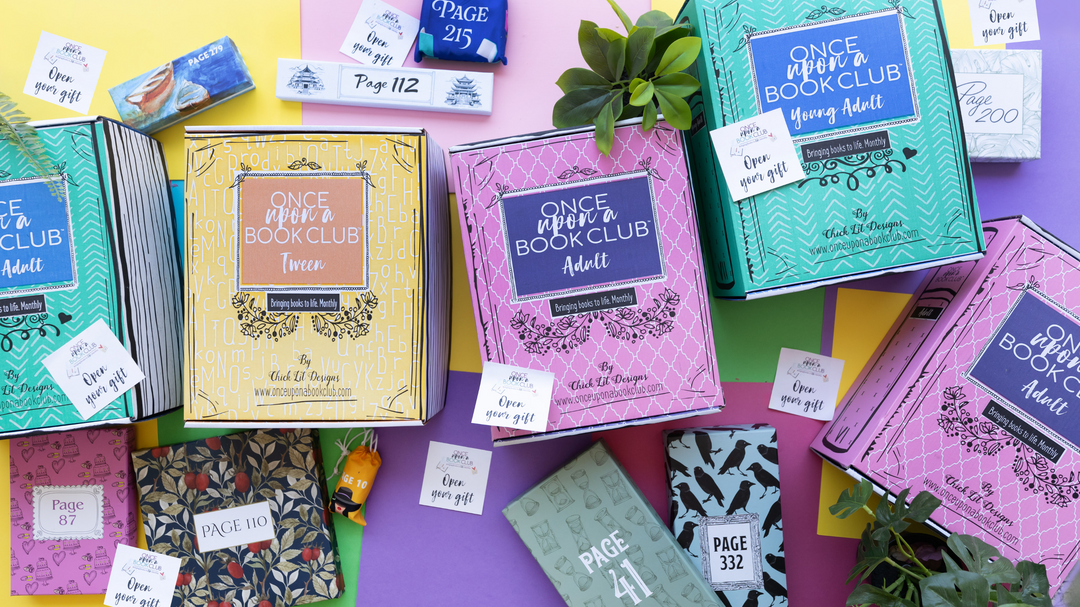 An assortment of Once Upon a Book Club book subscription boxes and wrapped gifts, each labeled with a page number, laid out on colorful paper.