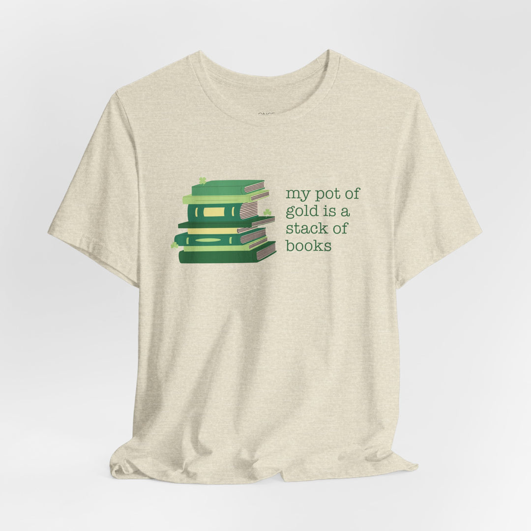 Beige t-shirt with green stack of books and clovers graphic and text "my pot of gold is a stack of books" on a white background