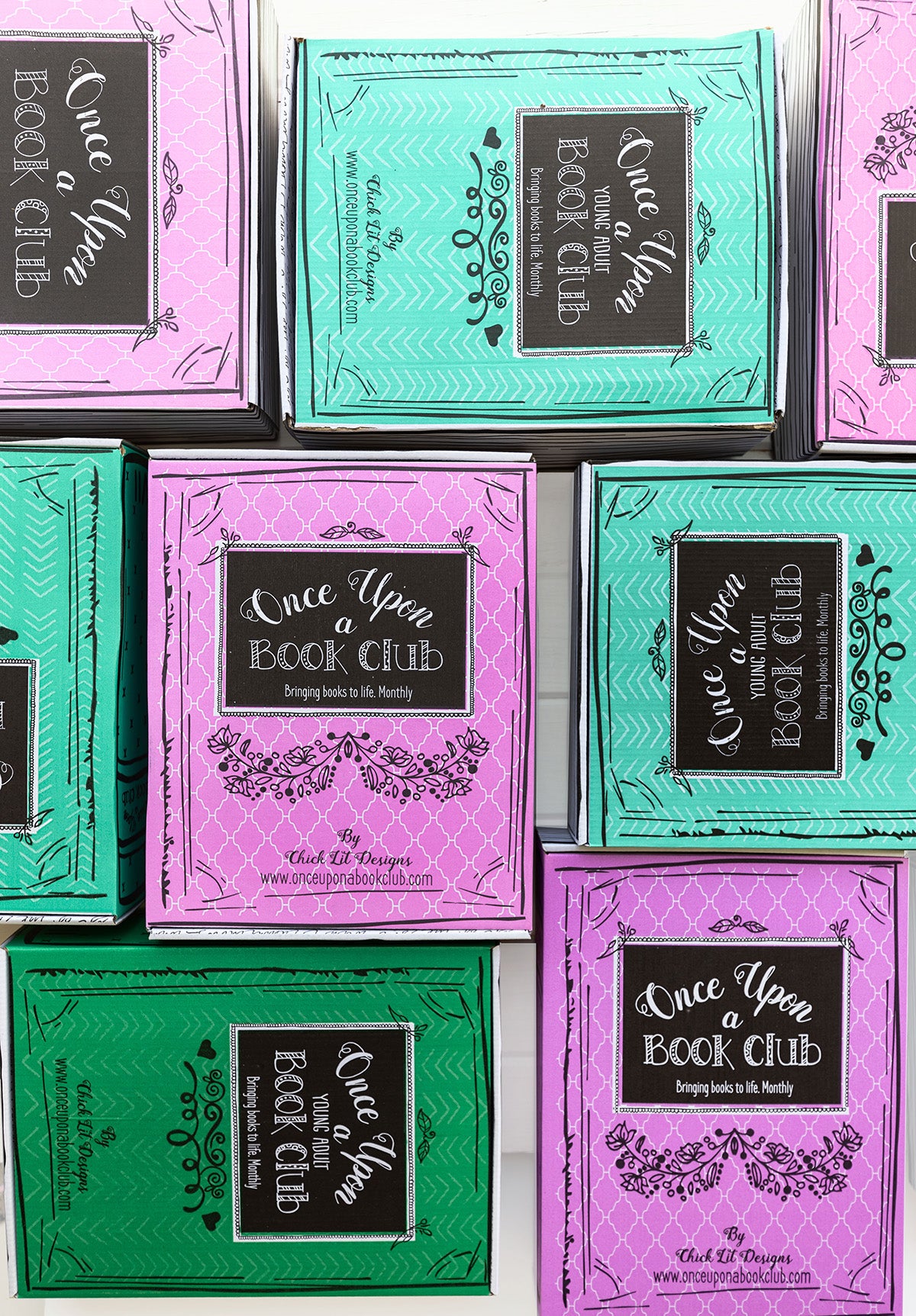 pink and green Once Upon a Book Club boxes are in a flat lay going different directions
