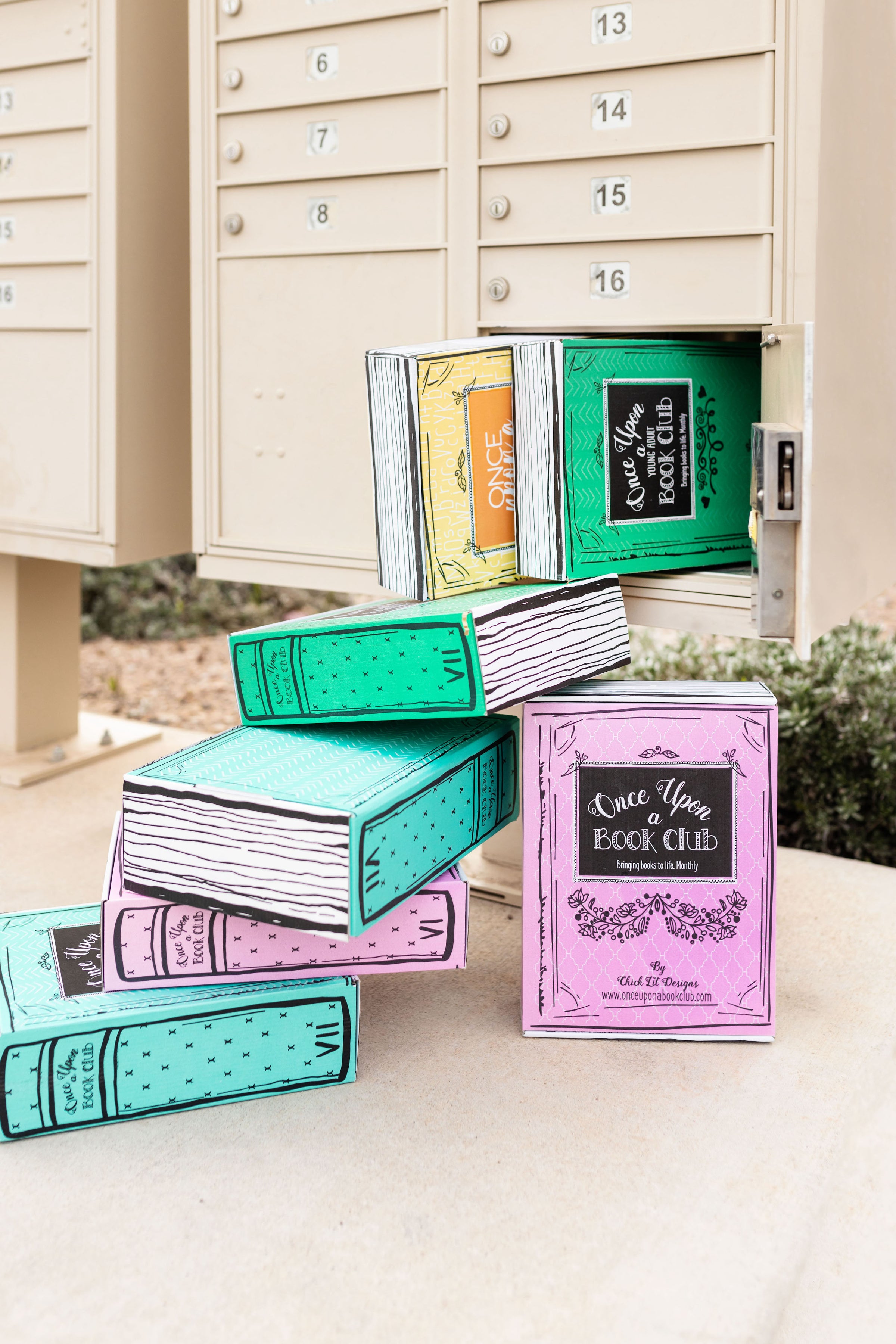 A collection of pink, green, and yellow Once Upon a Book Club boxes spilling out of a mailbox parcel locker.