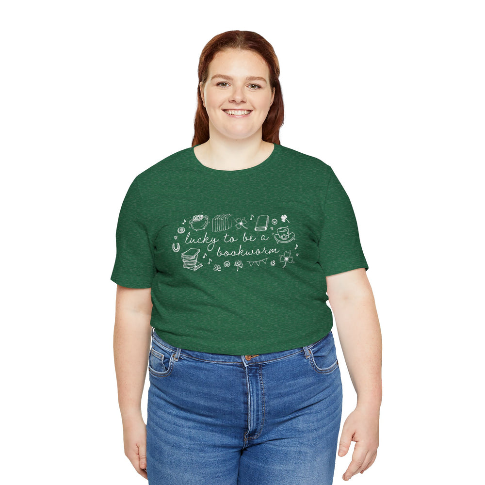 Person wearing green t-shirt with white font reading "lucky to be a bookworm" and line illustrations of St. Patrick's Day items and books on a white background