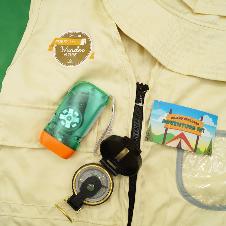 a flashlight and compass are on a tan vest that says "Worry Less, Wander More" along with a tag labeled "Island Explorer Adventure Kit"