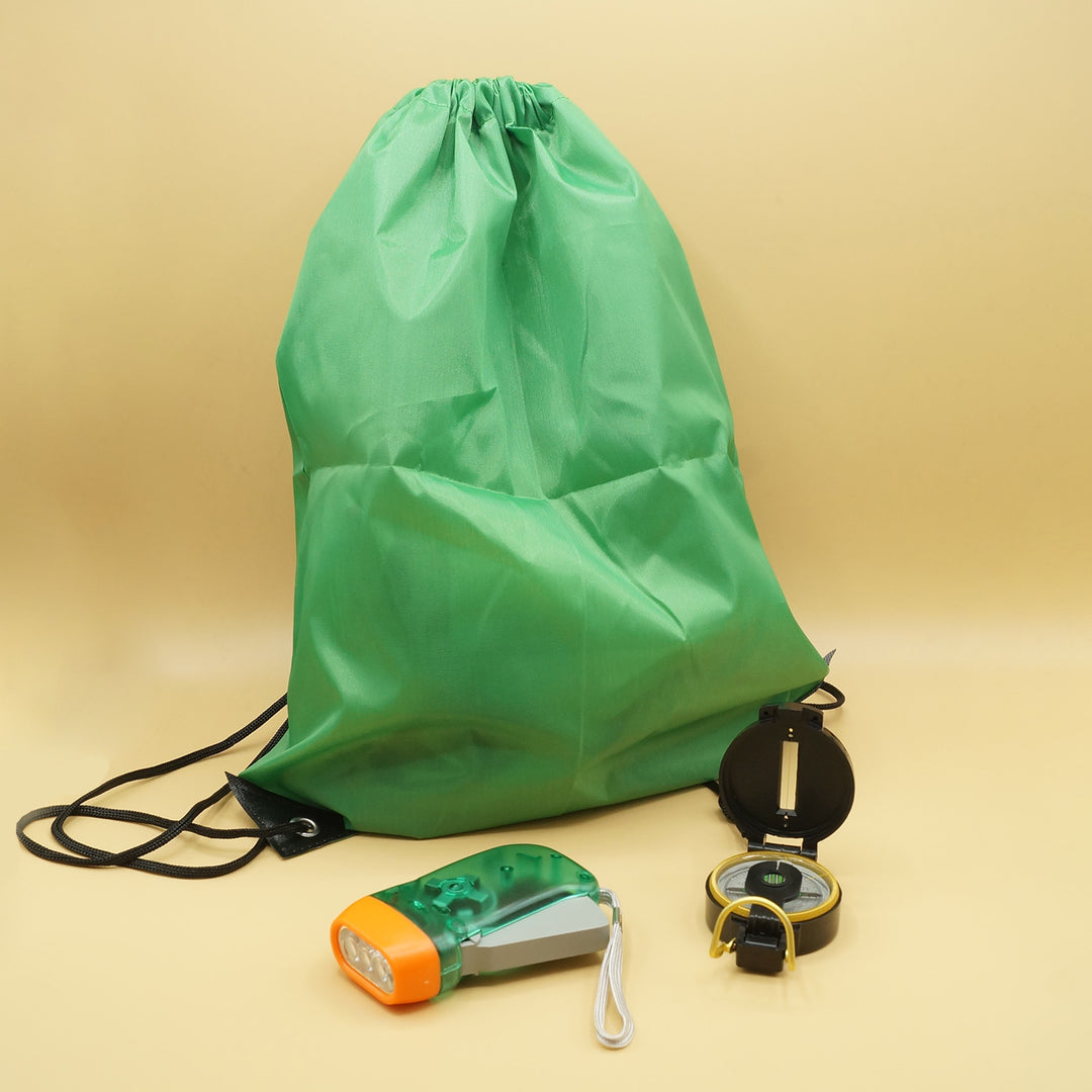 a green drawstring bag with a wind-up flashlight and compass in front of it