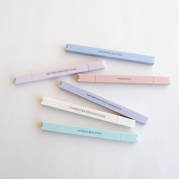 Set of pastel-colored pens with text on a light background