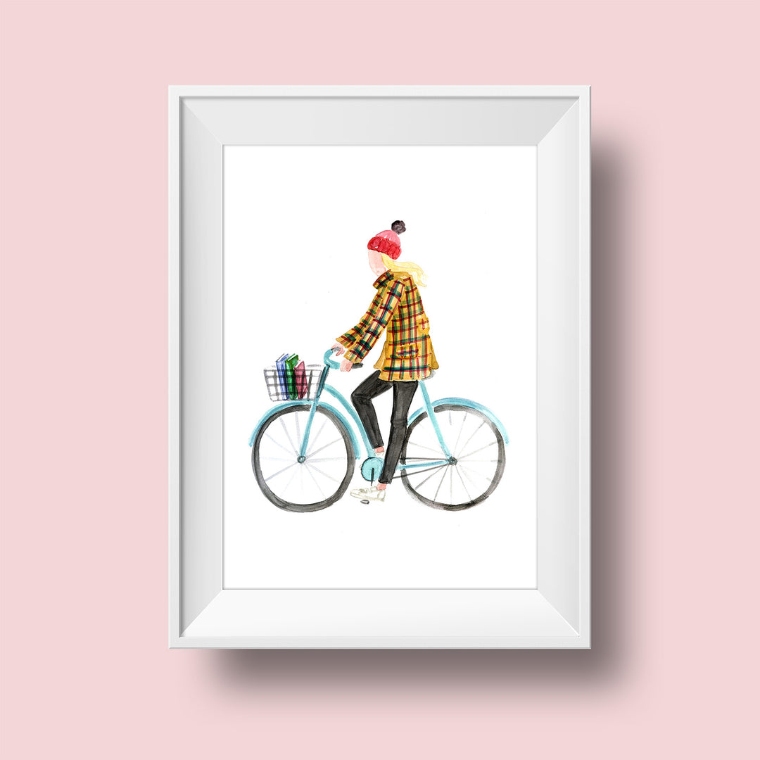 An illustration of a woman with a light skin tone and long blonde hair wearing a red winter hat. She is wearing a yellow jacket checkered with red and green, black pants, and white sneakers. She sits on a blue bicycle with three books in the front basket.
