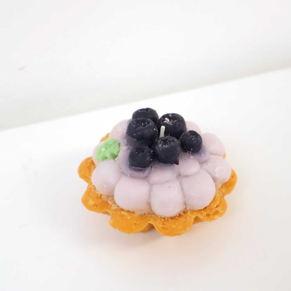 a candle in the shape of a berry tart.
