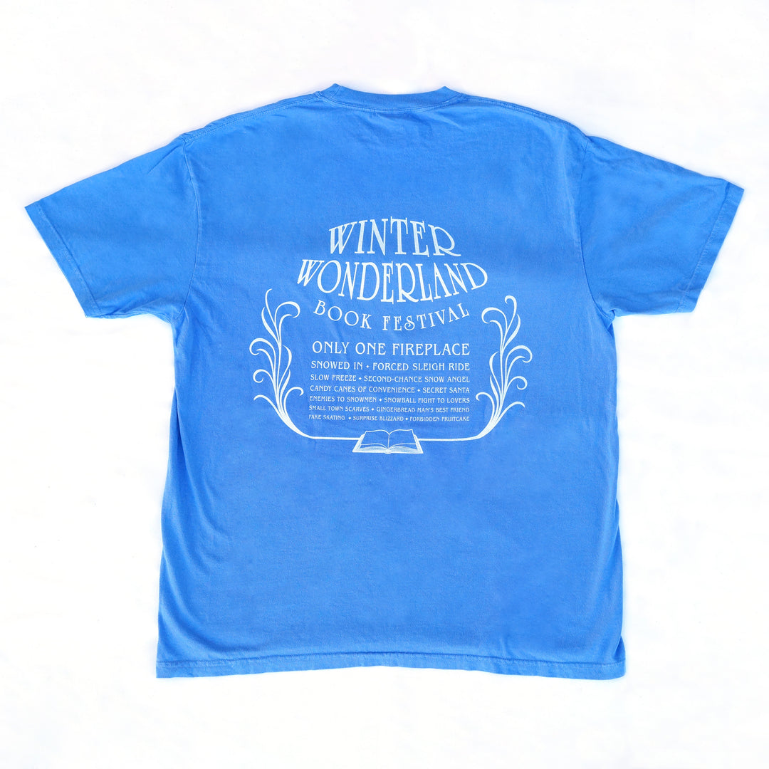 Blue t-shirt Winter Wonderland Book Festival with white romance trope-puns on the back on a white background
