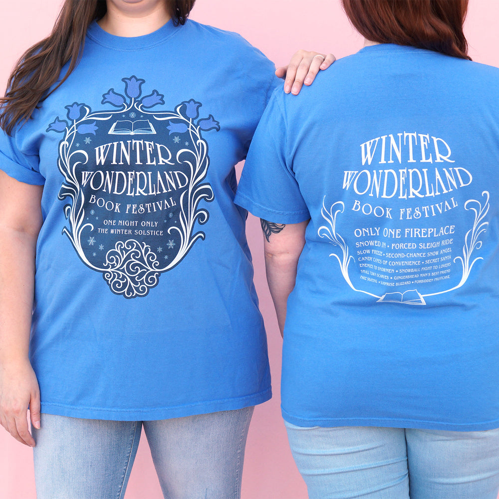 Two people wearing blue t-shirts with 'Winter Wonderland Book Festival' text and design.
