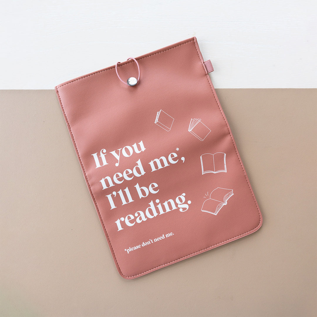 A booksleeve sits on a two-toned background. This booksleeve reads "If you need me*, I'll be reading *please don't need me" in white font on a terracotta background and white books.