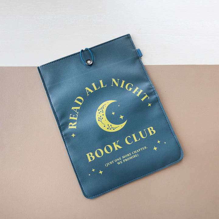 A booksleeve sits on a two-toned background. This booksleeve reads "Read All Night Book Club (just one more chapter, we promise)" in yellow font on a navy background and a yellow moon and stars.