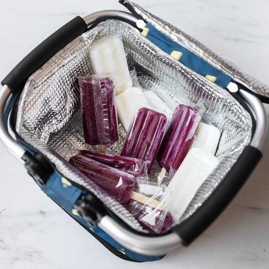 The cooler sits open to show the lined interior. The cooler is filled with ice pops.