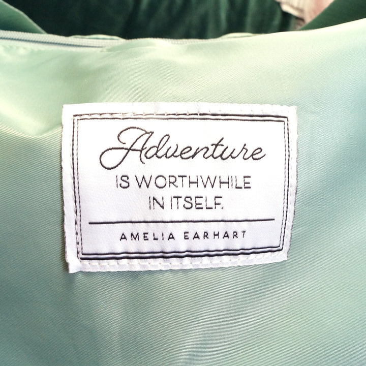 a white square that says "Adventure is worthwhile in itself - Amelia Earhart" on a light green background 