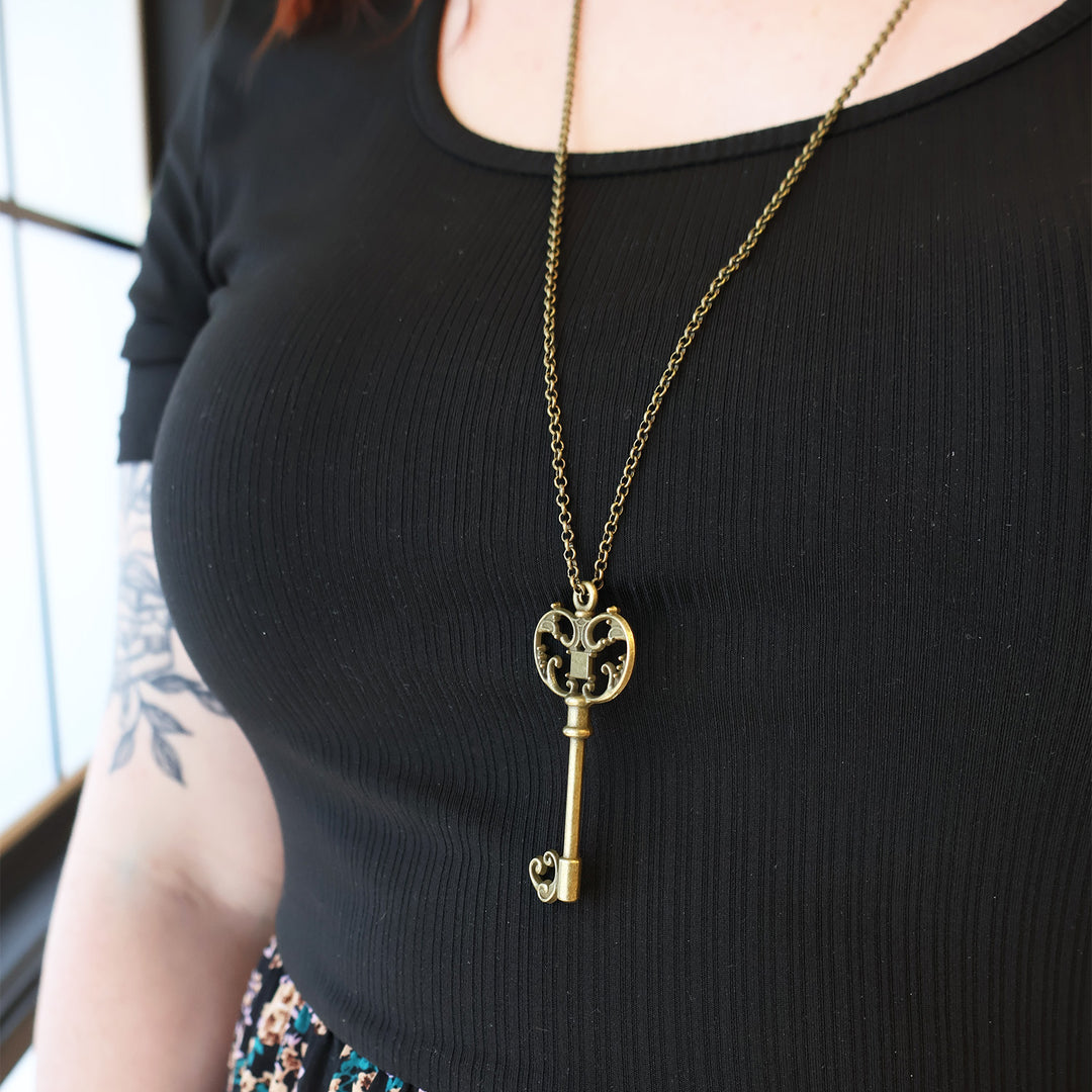 A woman wears a bronze key necklace.