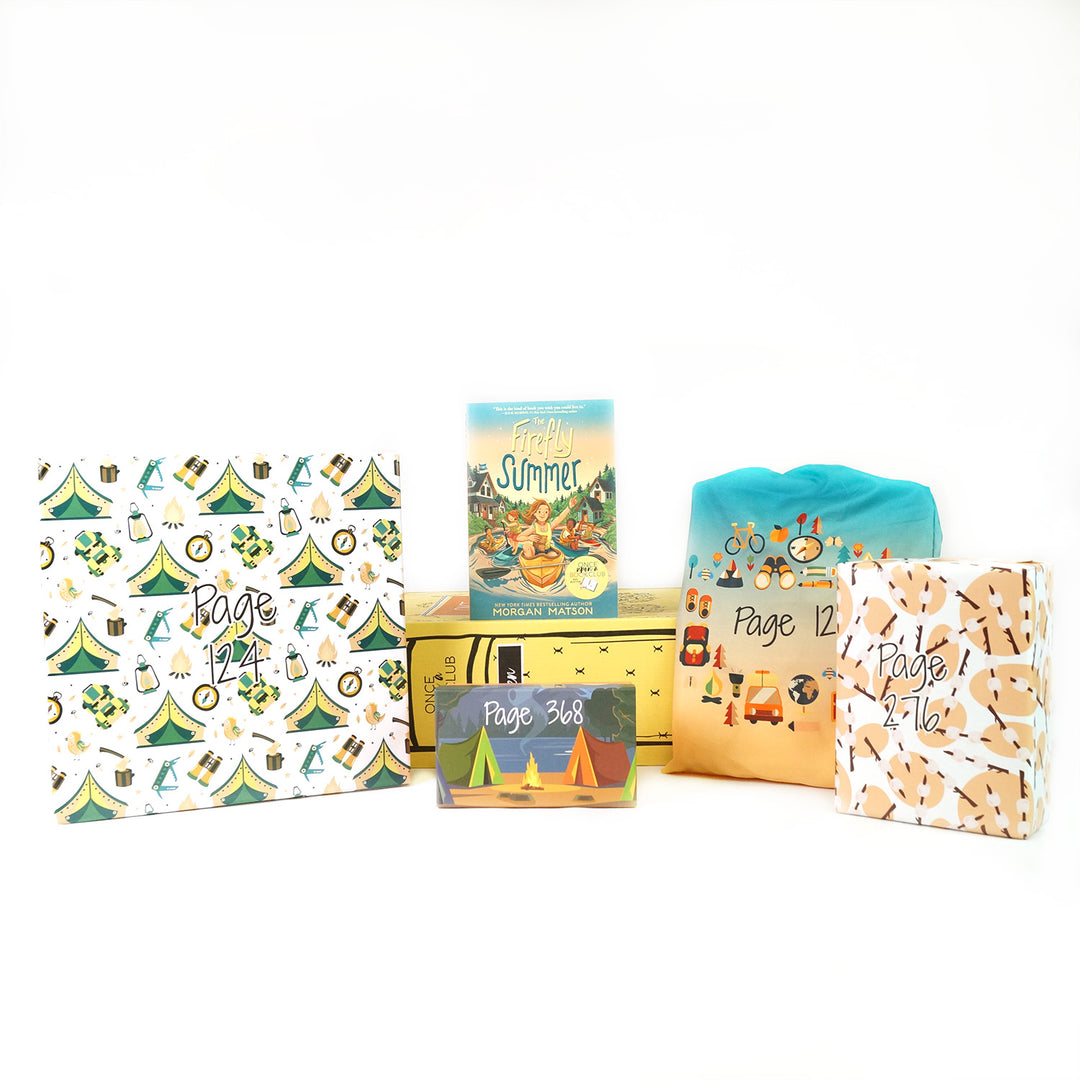 A paperback edition of The Firefly Summer stands on a yellow OUABC box. In front of the box are four themed wrapped gifts labeled with page numbers. Each gift has summer-themed wrapping paper.