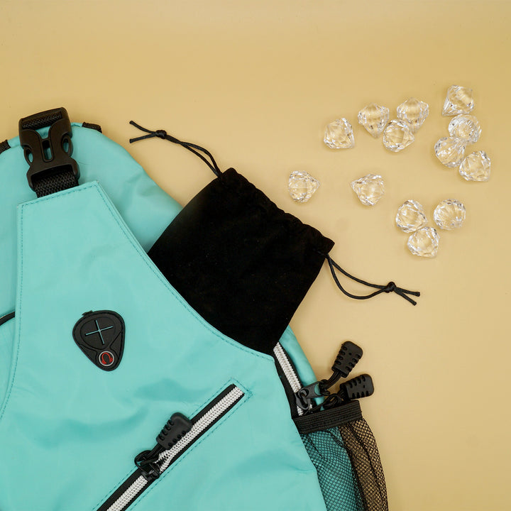 a teal shoulder backpack with a black drawstring bag coming out of it. Coming out of the black drawstring bag are fake diamonds