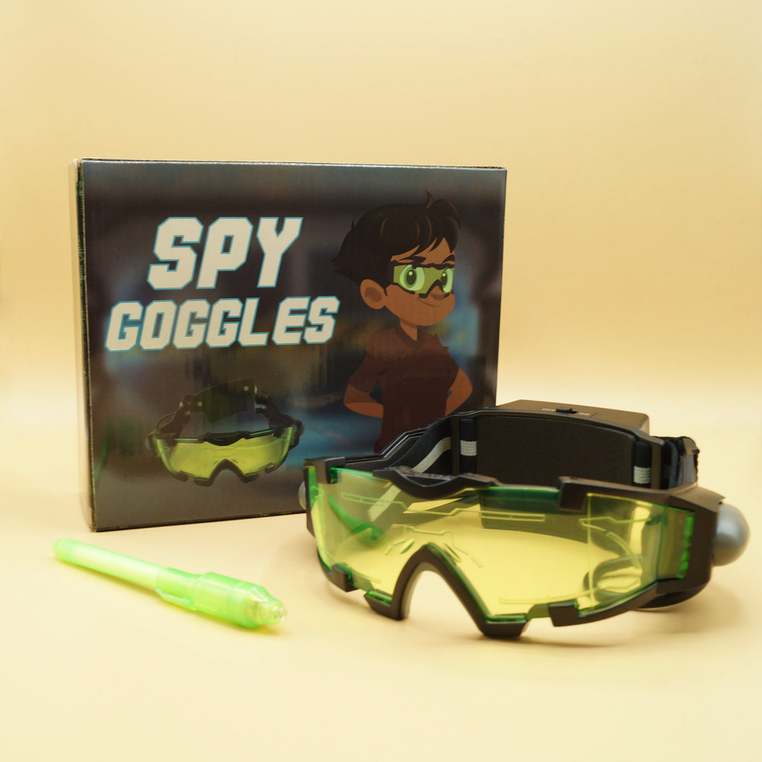 black and green spy goggles next to a box labeled Spy Goggles and a green glow-in-the-dark pen