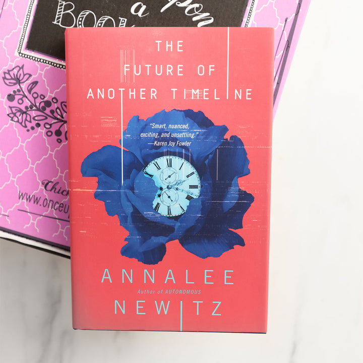 a hardcover copy of The Future of Another Timeline on top of a pink box