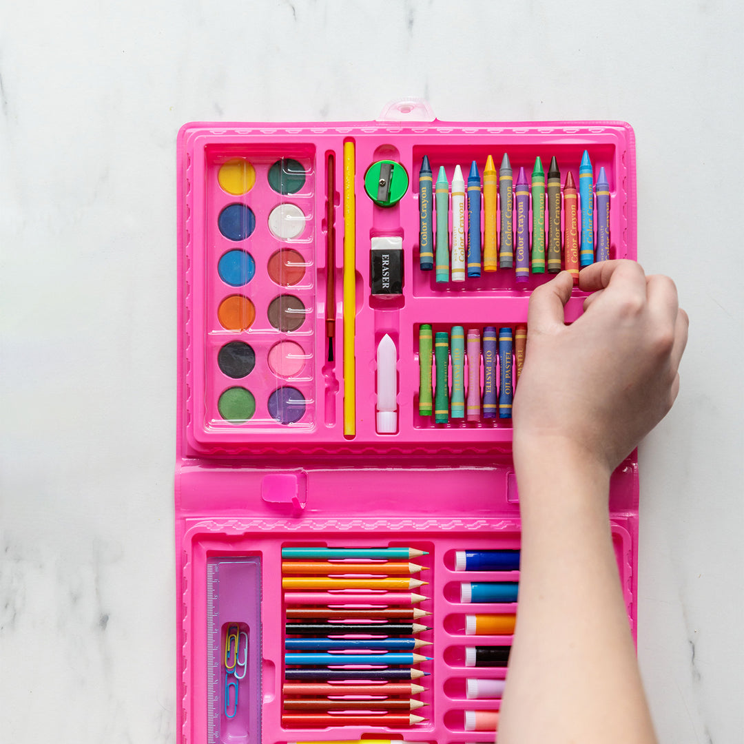 A white hand reaches for a crayon from the interior of the art kit.