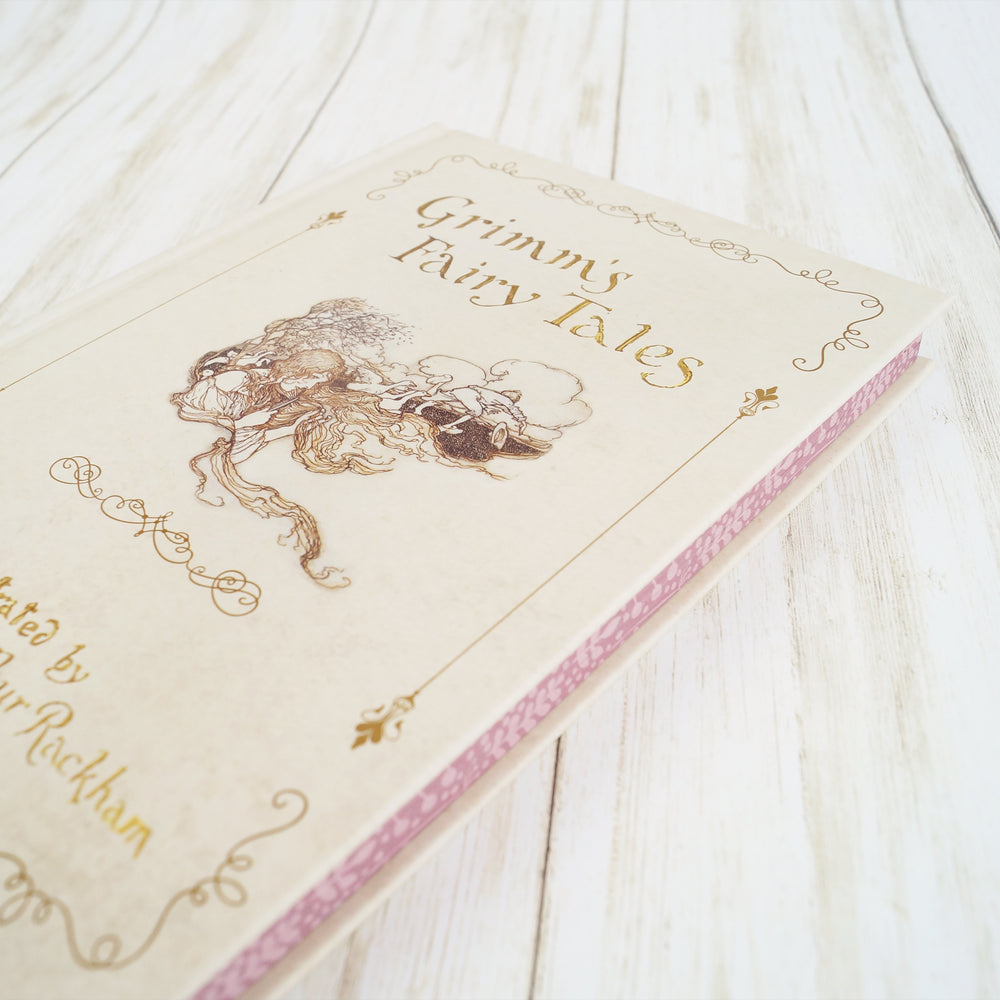 a closed copy of GRIMM'S FAIRY TALES showing the pink page edges.