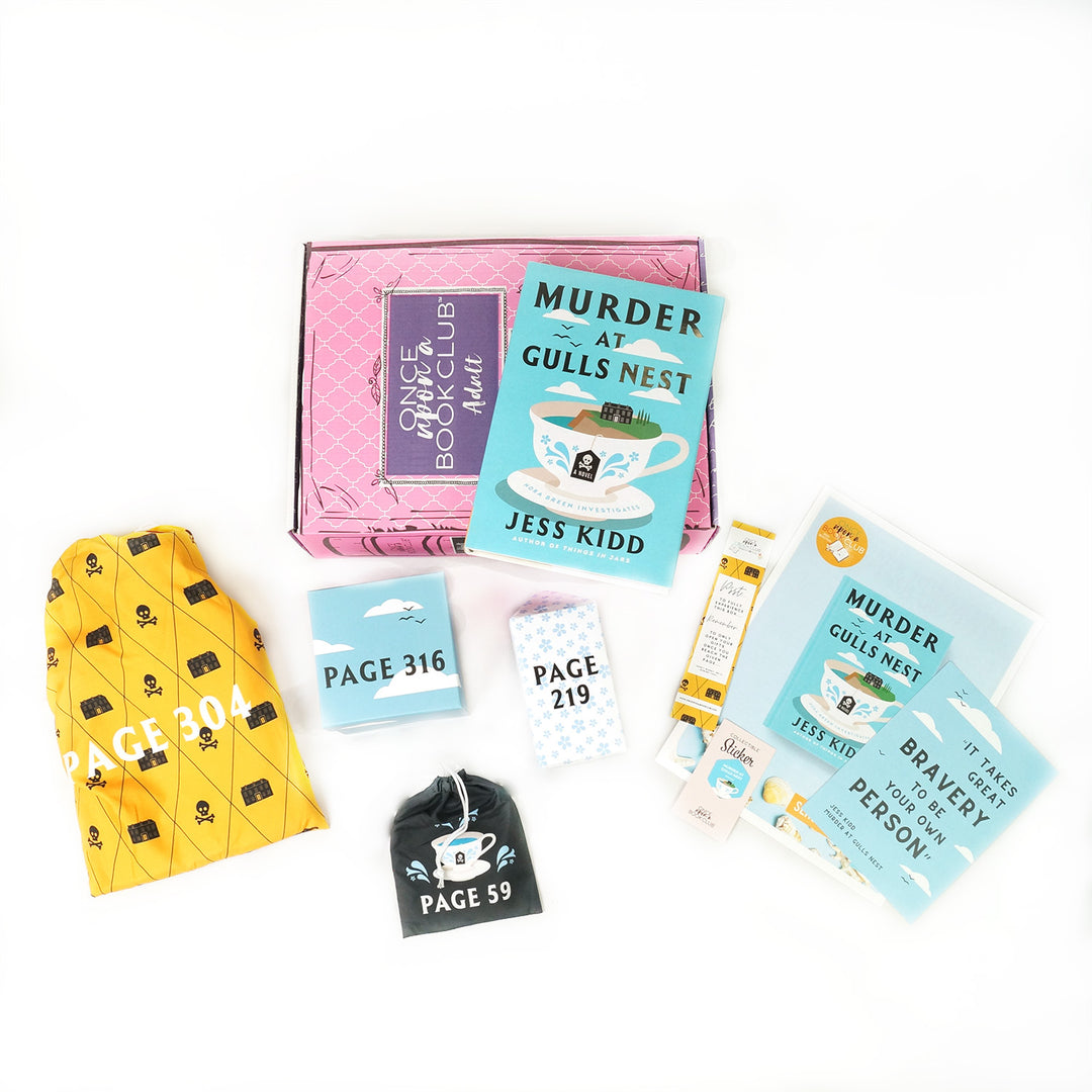 An exclusive edition of Murder at Gull's Nest by Jess Kidd on a pink OUABC box surrounded by wrapped gifts and paper items.