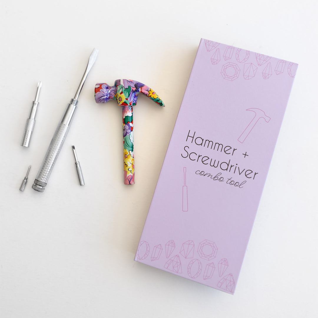 A purple box labeled Hammer + Screwdriver combo tool. Next to the box is a silver handle, small tools, and a hammer head with a floral pattern.