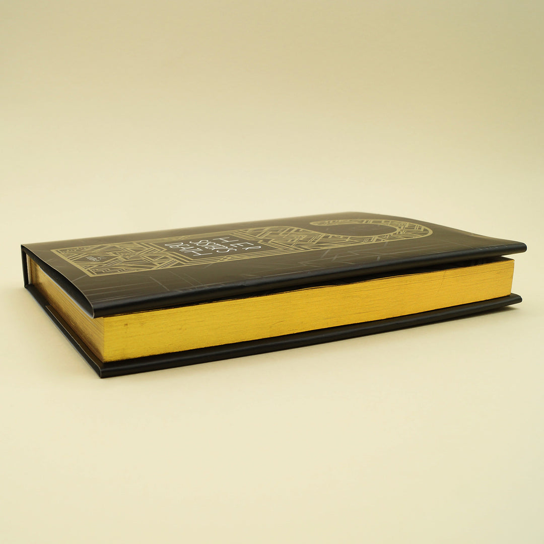 hardcover special edition of Her Sister's Death lays on its side, showing gold sprayed edges