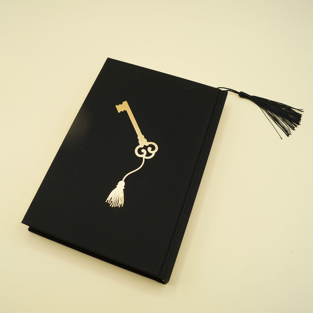 front hardcase of special edition of Her Sister's Death, black with a golden key and tassel at the center