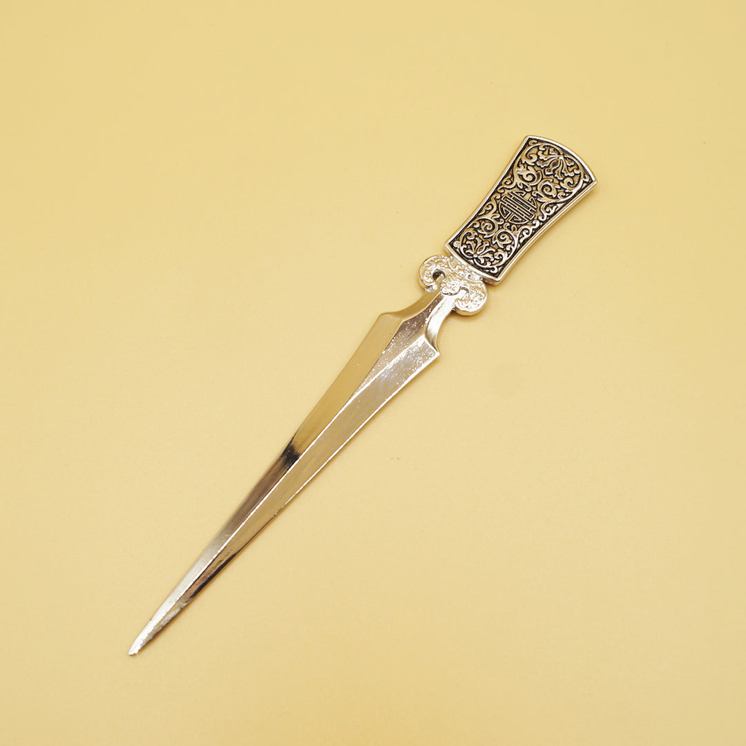 a silver letter opener with intricate design on the handle