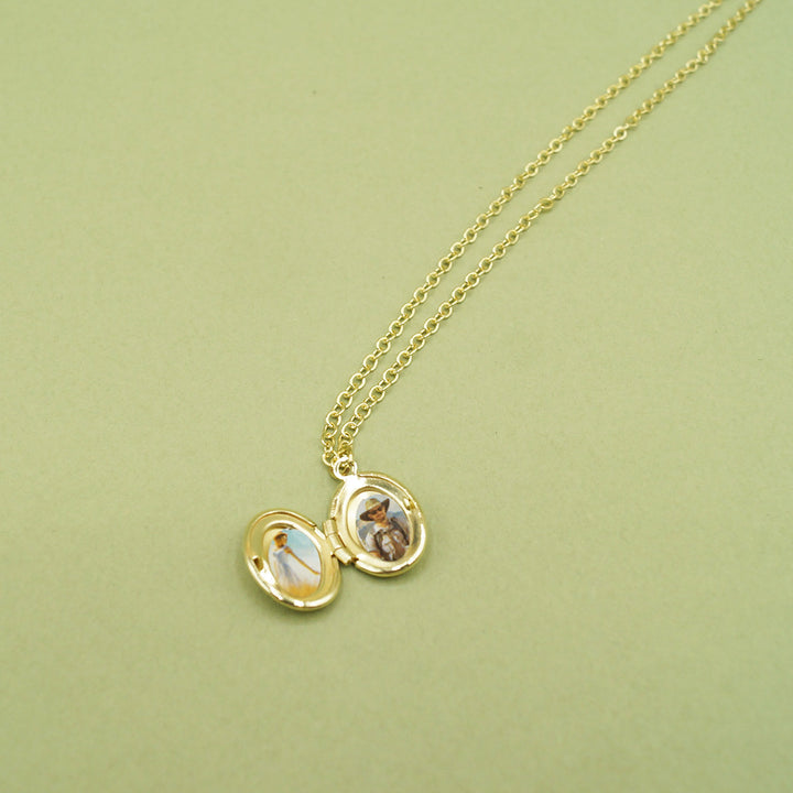 a gold miniature locket necklace against a green background