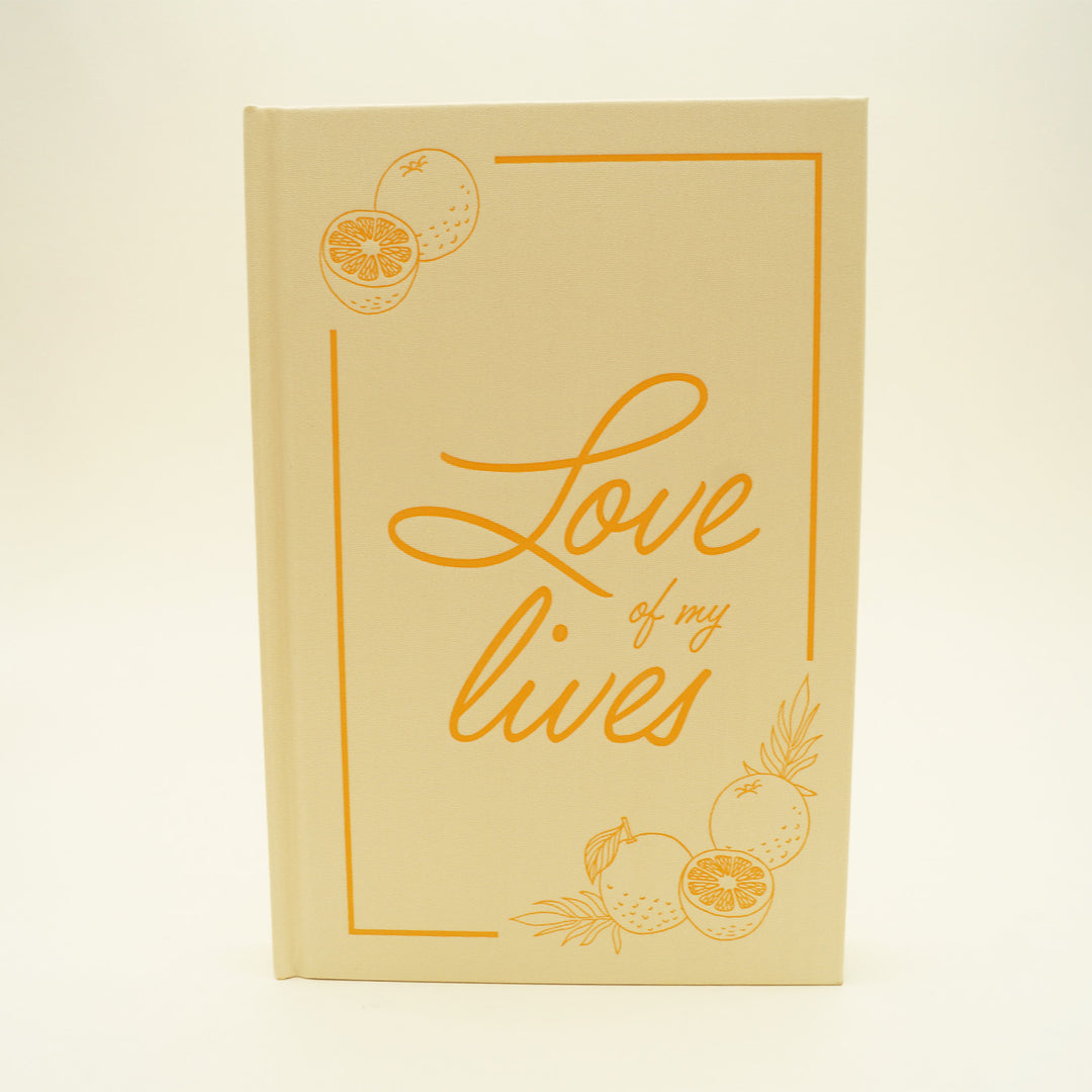 the front of a hardcover copy of "Love of my Lives" with oranges in the top left and bottom right