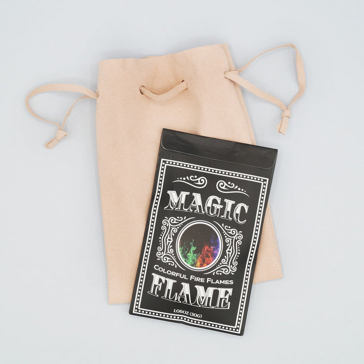 a black packet labeled Magic Flame - colorful fire flames - is on top of a pink drawstring bag