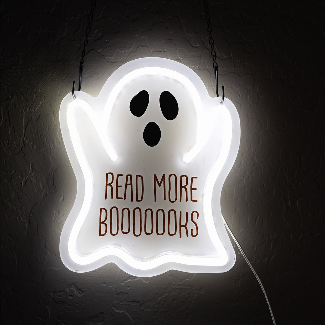 An LED sign in the shape of a ghost that says Read More Booooooks in orange text on the front. The sign hangs from a metal chain.