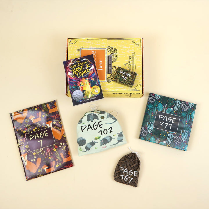A paperback edition of The Total Eclipse of Nestor Lopez lays on a yellow OUABC box next to a wrapped gift labeled with a page number. In front of the box are four more themed wrapped gifts labeled with page numbers.