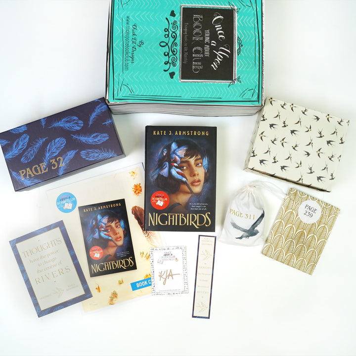 A green Once Upon a Book Club box is at the top of the image. In front of the box are a black and blue rectangular box, quote card, bookclub kit, signature card, hardcover edition of Nightbirds, bookmark, white drawstring bag, white box, and gold envelope. The boxes and envelope all have page numbers.