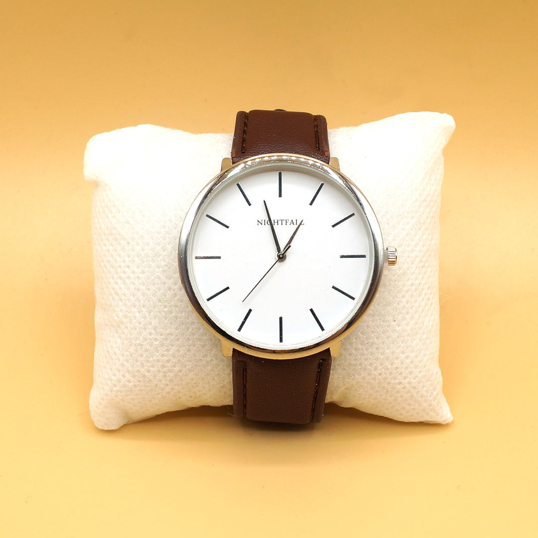 a brown wristwatch with a white clock-face is on a white pillow