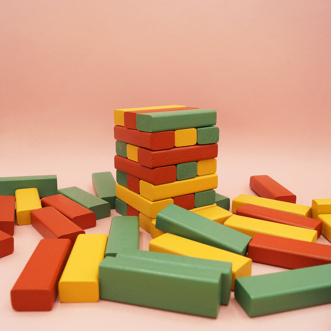 A collection of blocks is strewn haphazardly across the forefront of the image. A multi-colored tower sits half built toward the back of the image.
