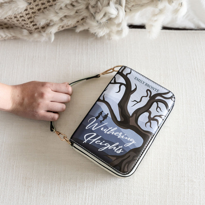 "Wuthering Heights" book-inspired purse with tree design, resting on a cozy beige surface.
